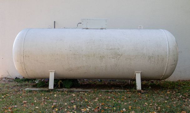 propaan gastank in een tuin  - Foto, afbeelding