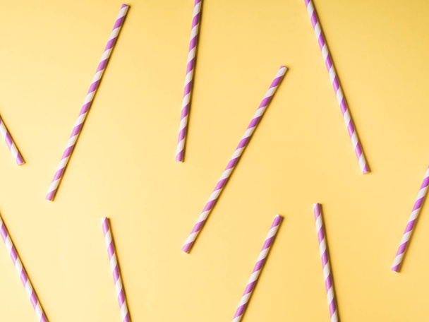 Purple paper straws on yellow color background. - Photo, Image