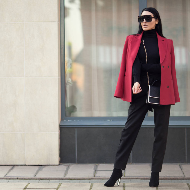 Γυναίκα της μόδας με κόκκινο παλτό στέκεται στην πόλη. Επιχειρηματίας. Μπάτσος - Φωτογραφία, εικόνα