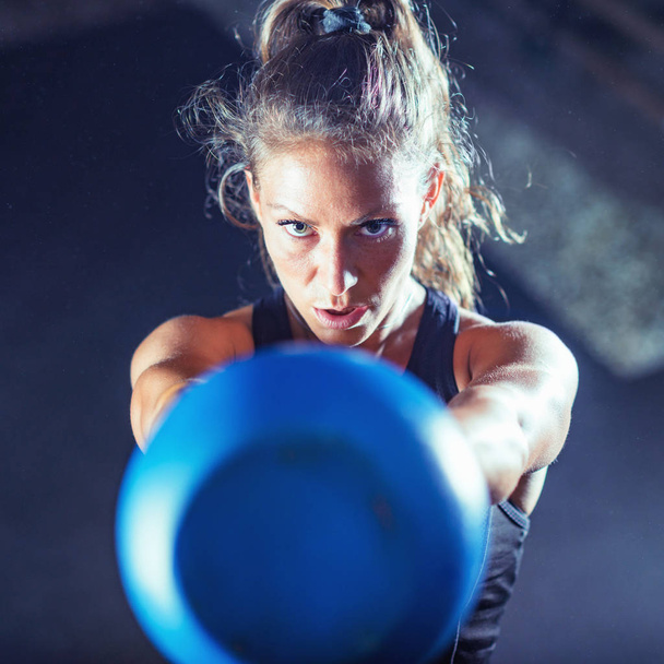 Woman athlete exercising with kettlebell indoors - Fotoğraf, Görsel