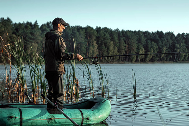 Чоловік-рибалка на озері стоїть у воді і рибалка для риболовлі. Концепція риболовного хобі відпустки. Копіювати простір
. - Фото, зображення