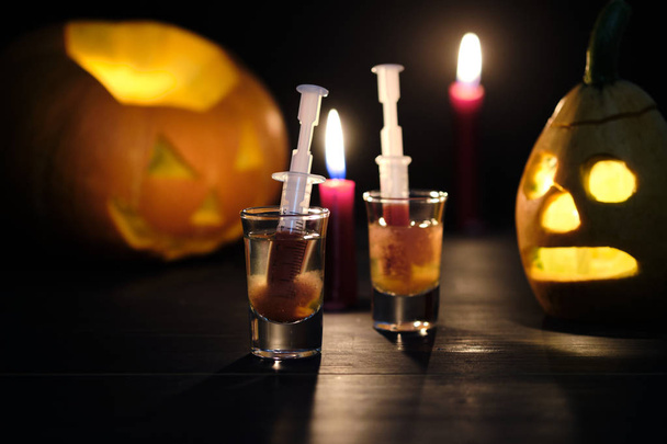Halloween sangrento mary cocktail e duas lanternas sinistras jack em uma mesa de madeira escura
. - Foto, Imagem