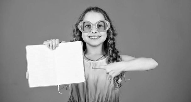 reading book. Summer fashion. diary notes. making plans for summer holidays and vacation. small beauty girl write her memories. small happy girl in glasses with notebook. copy space. publishing house - Foto, Imagem