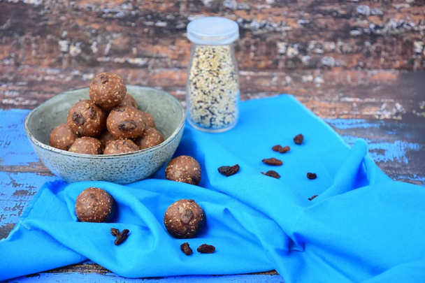 Homemade healthy energy balls with chocolate, raisin, quinoa and oat on blue background - Photo, image