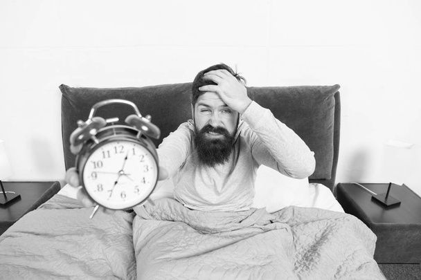 Hate this noise. Problem with early morning awakening. Get up early. Tips for waking up early. Man bearded hipster sleepy face waking up. Daily schedule for healthy lifestyle. Alarm clock ringing - Фото, изображение