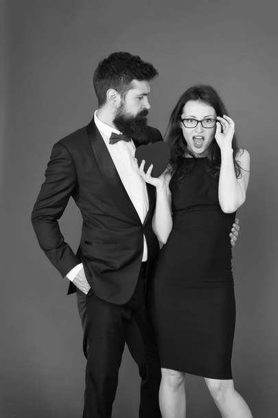 Do not play with my heart. Man with beard and woman happy celebrate anniversary. Couple in love dating anniversary. Man tuxedo and girl hold hear soft toy romantic anniversary. Valentines day holiday - Photo, image