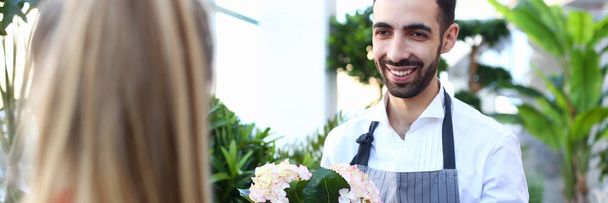 Uśmiechnięty włoski sprzedawca kwiatów rozciąga - Zdjęcie, obraz