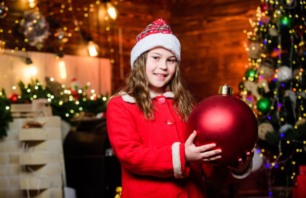 Sparkling big toy. Merry christmas. Festive atmosphere christmas day. Girl santa claus costume hold big ball christmas tree ornaments. Christmas decorations. Love to decorate everything around - 写真・画像
