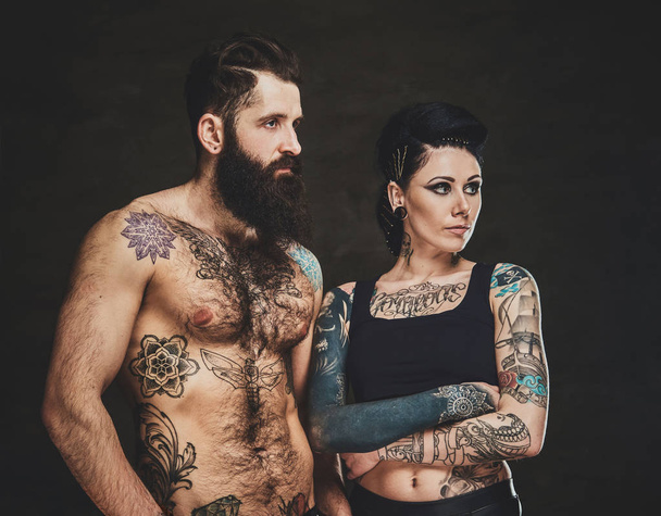 Tetovált férfi és nő portréja a fotóstúdióban - Fotó, kép