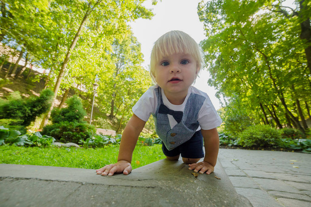 Piccolo ragazzo felice striscia sull'asfalto nel parco
. - Foto, immagini
