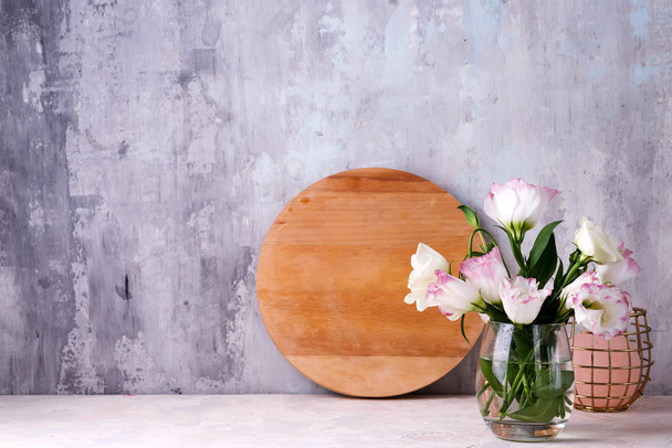 Eustoma virágok vázában az asztalon közel kő fal, helyet a szöveges. Képeslapokhoz üres - Fotó, kép
