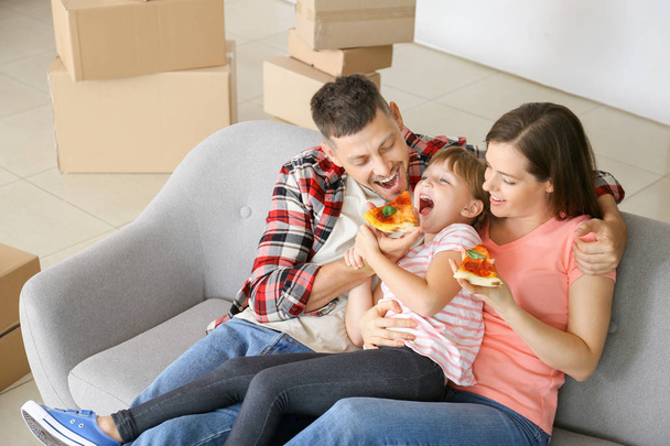 Щаслива сім'я їсть піцу в рухомий день
 - Фото, зображення