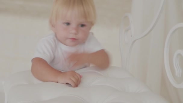 Beautiful happy little boy is playing in the white room. - Felvétel, videó