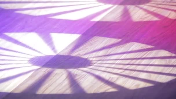světlo reflektorů v podobě slunečního světla se otáčí na dřevěné podlaze - Záběry, video