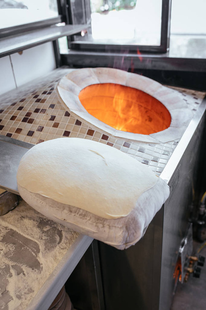 Παραδοσιακό τούρκικο ραμαντάν ψωμί πίτας, πίτας, lavash ή yufka σε πέτρινο φούρνο ψησίματος φωτιάς γνωστό και ως "Tandir or Tandoor" - Φωτογραφία, εικόνα