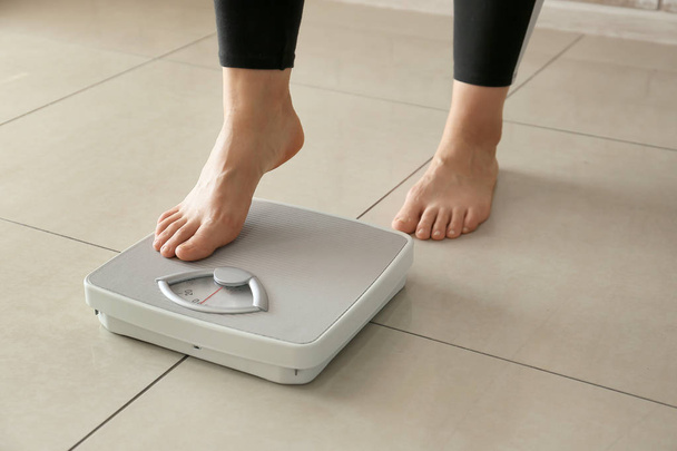 Woman with scales at home. Weight loss concept - Фото, изображение
