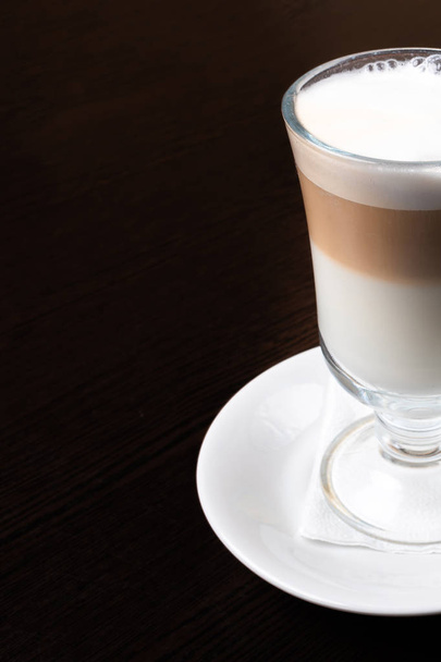 Mug of latte, on a dark, wooden background.  - Foto, afbeelding