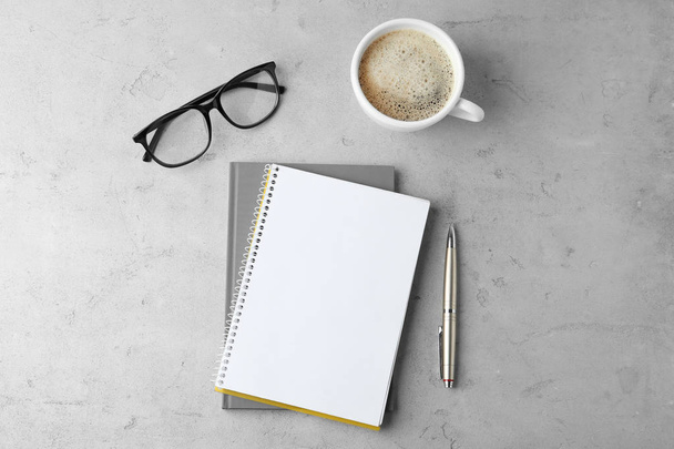 Flat lay composition with office stationery and cup of coffee on light stone background. Space for design - 写真・画像