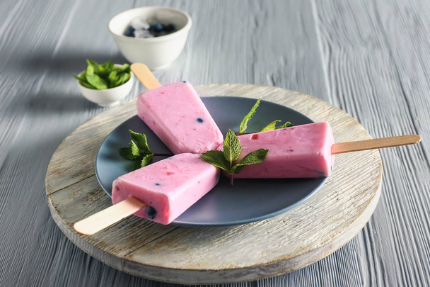 Plate with tasty blueberry ice cream on wooden table - Photo, image