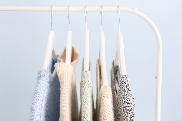 Rack με χειμωνιάτικα ρούχα στο φόντο χρώμα - Φωτογραφία, εικόνα