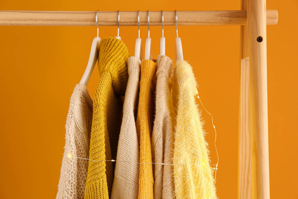 Rack with winter clothes on color background - Фото, зображення