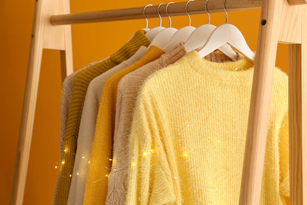 Rack with winter clothes on color background - Photo, Image