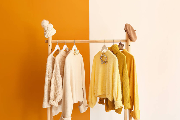 Rack with winter clothes on color background - Photo, Image