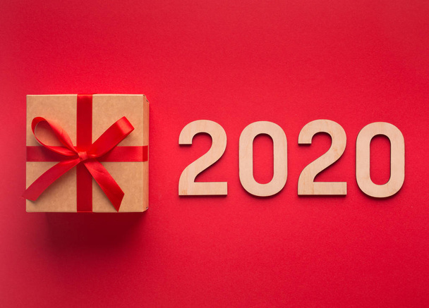 Vendita anno nuovo 2020 con scatola regalo e numeri di legno su rosso
 - Foto, immagini