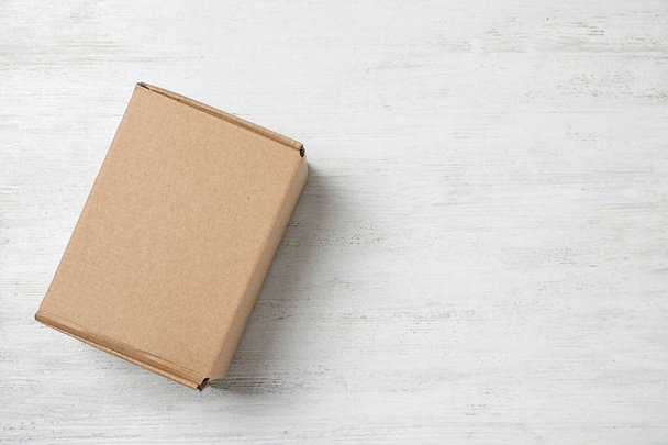 Cardboard box on white wooden background, top view. Space for text - Foto, immagini