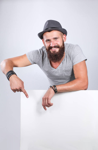 Portrait of young man in hat standing near blank, isolated on white background - Φωτογραφία, εικόνα