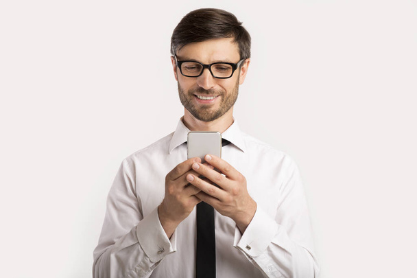 Businessman Texting On Phone Standing Over White Background, Studio Shot - Fotografie, Obrázek