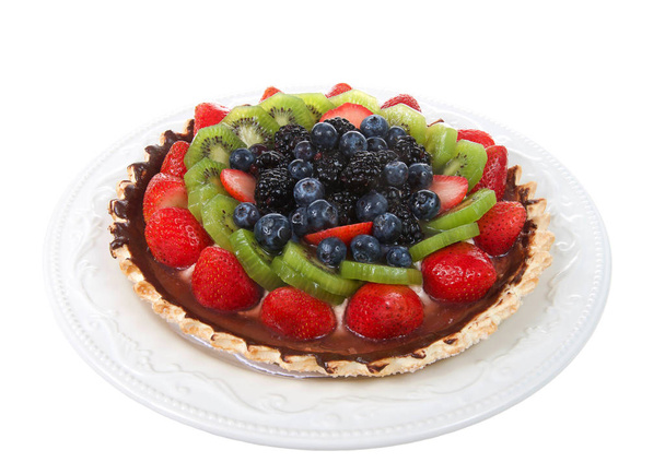 Verse fruit taart op een gebakje korst bedekt met chocolade op een witte plaat geïsoleerd op witte achtergrond. Focus gestapeld voor diepere scherptediepte. - Foto, afbeelding