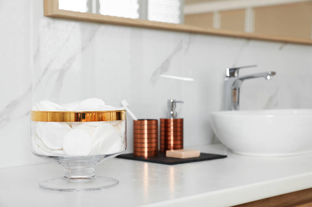 Jar with cotton pads on bathroom countertop - Фото, изображение