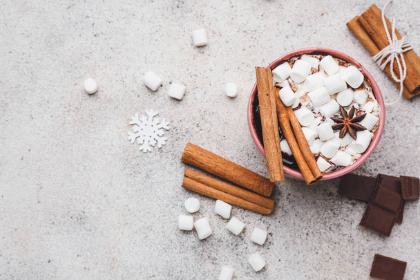 Cup of hot chocolate with marshmallows and cinnamon on light background - Foto, Bild