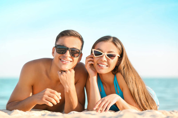 Young couple resting on sea beach - Foto, imagen