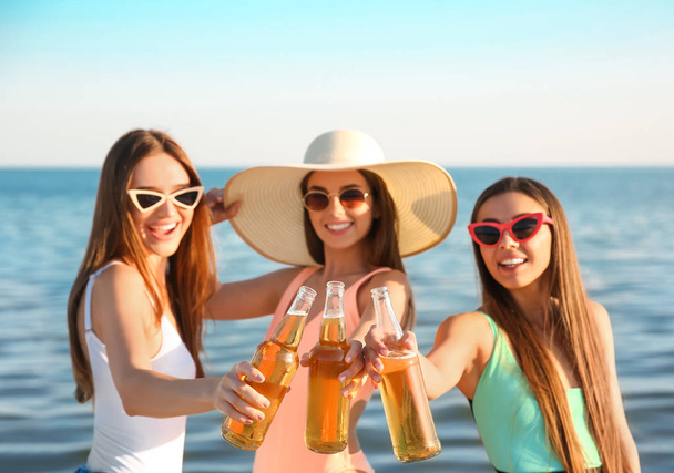 Amigos bebendo cerveja na praia do mar
 - Foto, Imagem