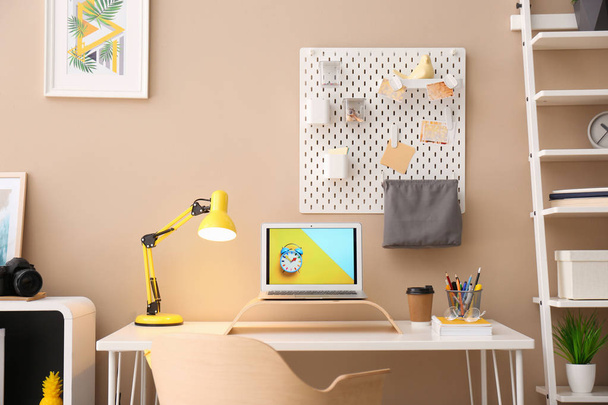 Modern laptop on desk in room. Home workplace - Zdjęcie, obraz