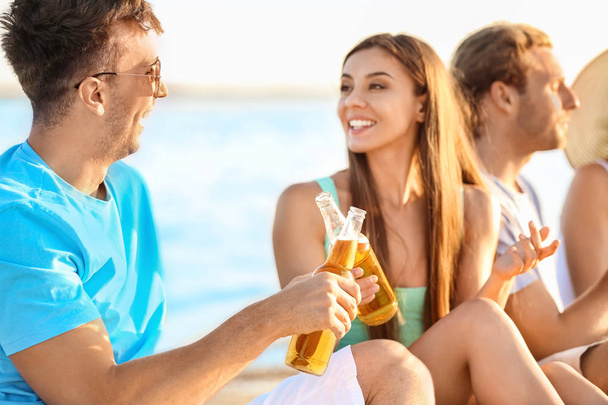 Ystävät juomassa olutta meren rannalla
 - Valokuva, kuva
