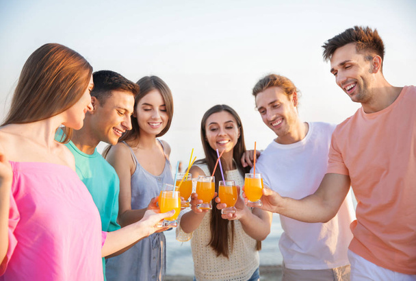 Friends drinking juice on sea beach - Valokuva, kuva