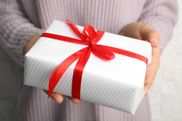 Young woman holding Christmas gift, closeup view - Photo, Image