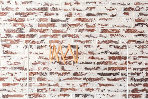 Scaffale con appendiabiti contro muro di mattoni
 - Foto, immagini