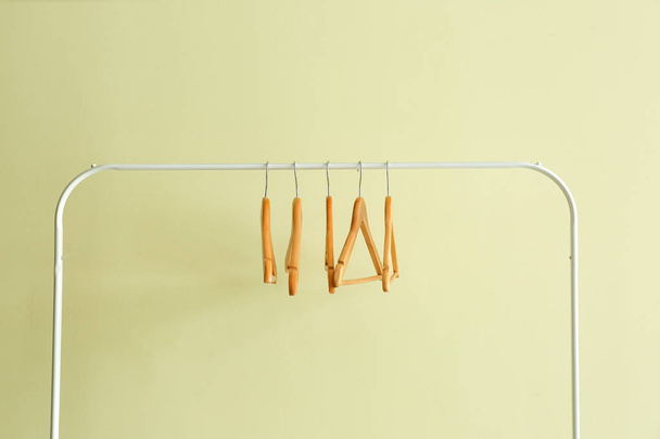 Rack met kleding hangers op kleur achtergrond - Foto, afbeelding