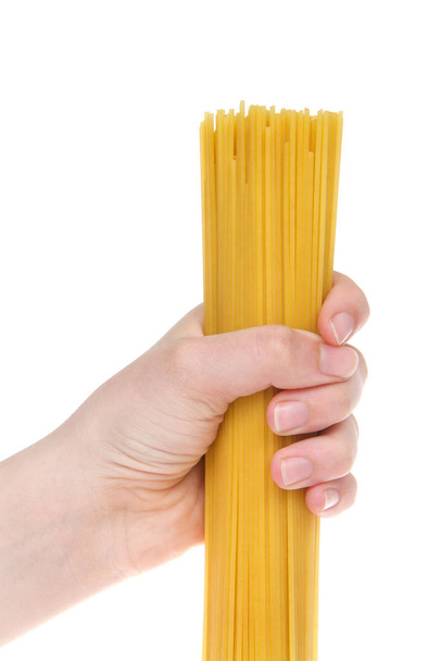 Young female hand holding dry spaghetti pasta isolated on white background. close up. - Photo, Image