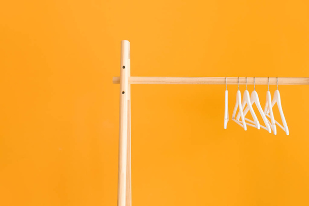 Rack with clothes hangers on color background - Photo, Image