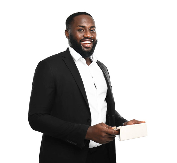 Handsome African-American businessman with mobile phone on white background - Photo, Image