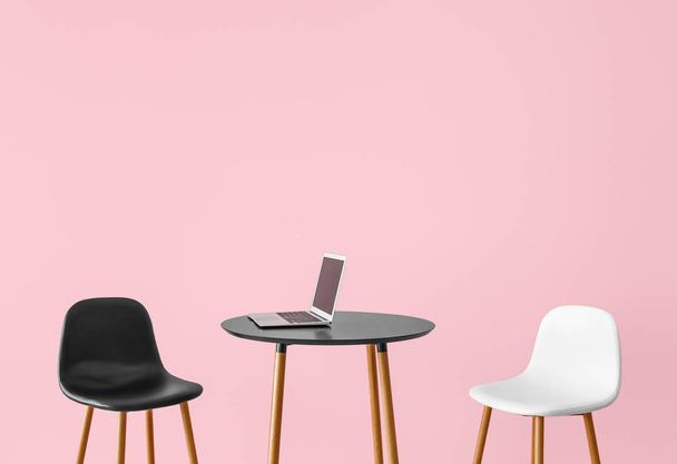 Krzesła i stół z laptopem w pobliżu ściany koloru - Zdjęcie, obraz