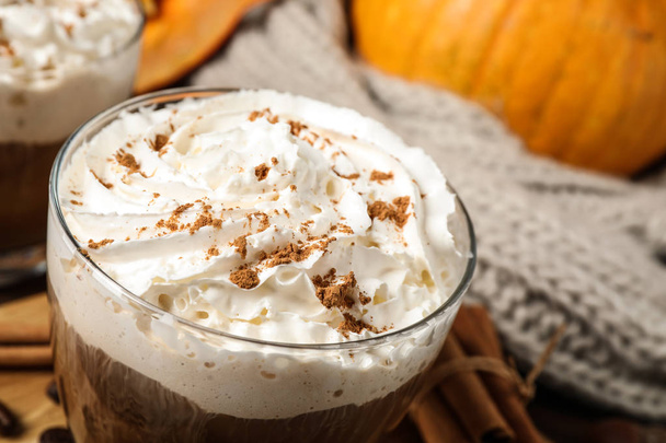 Glass with tasty pumpkin spice latte on table, closeup - Фото, изображение