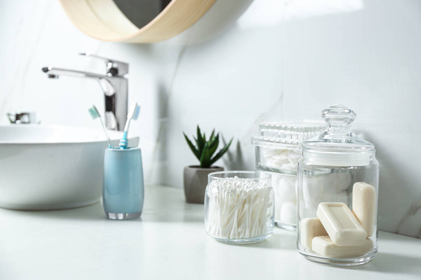 Cotton swabs and soap bars on white countertop in bathroom - Foto, imagen