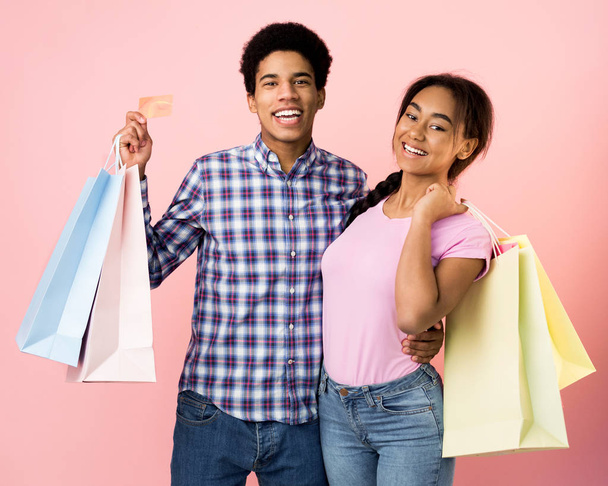 Adolescentes felices con bolsas de compras sobre fondo rosa
 - Foto, imagen