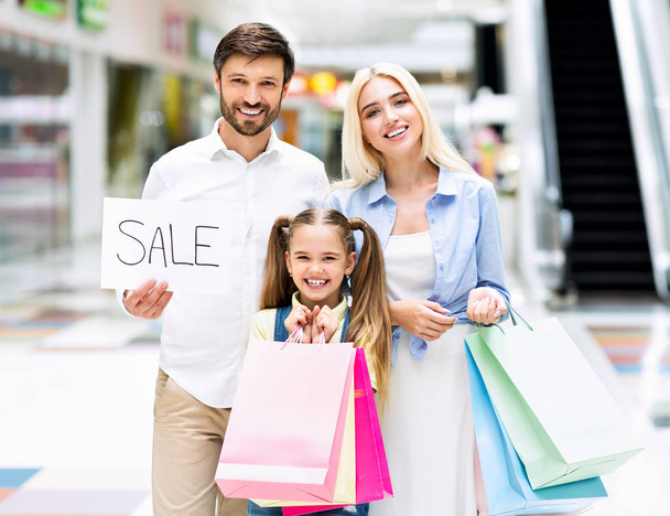 Family Holding Shopping Bags And Sale Sign Standing In Mall - Photo, Image
